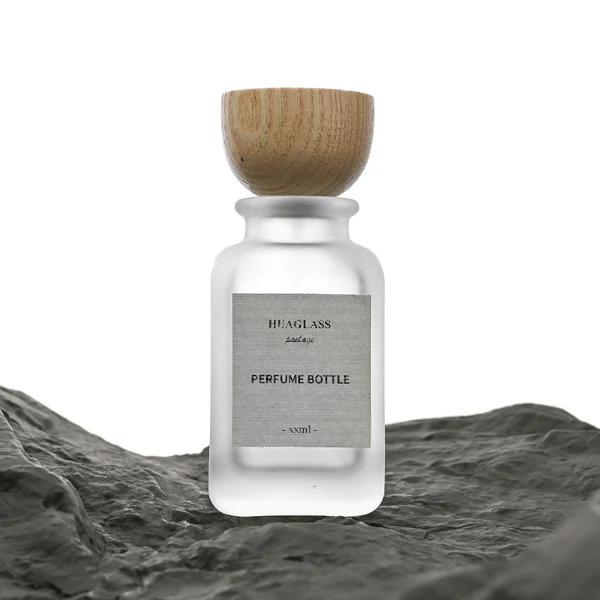 HUA0041 perfume bottle, frosted clear or smoky grey gradient cylindrical round glass bottle featuring an eye-catching inverted conical cup-shaped wood cap with prominent natural wood grain lines, elegant modern fragrance packaging design available in 30ml, 50ml, and 100ml