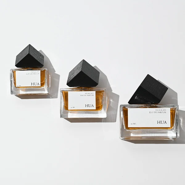 Modern cube-shaped caps featuring a glossy black finish.Sleek rectangular perfume bottles crafted from heavy-base clear glass filled with golden-amber liquid.