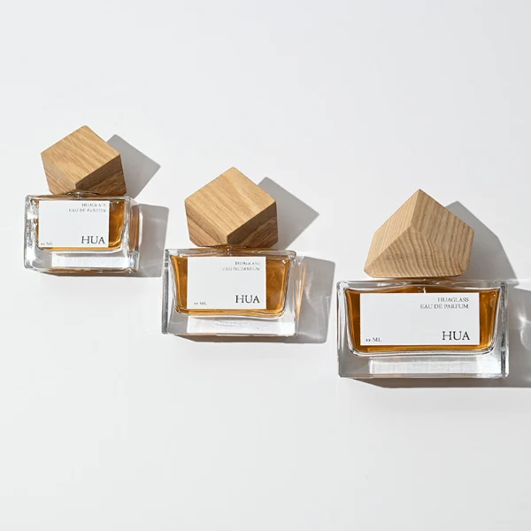 Modern cube-shaped caps featuring a glossy black finish.Sleek rectangular perfume bottles crafted from heavy-base clear glass filled with golden-amber liquid.