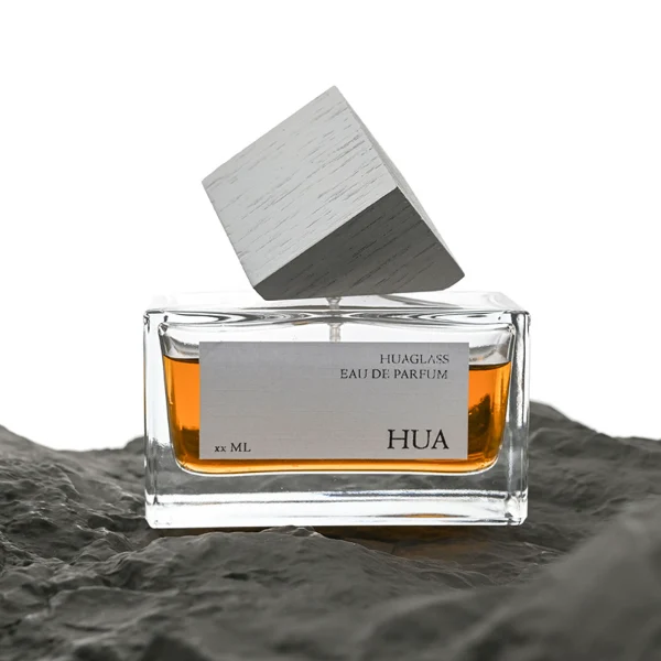 Modern cube-shaped caps featuring a glossy black finish.  Sleek rectangular perfume bottles crafted from heavy-base clear glass filled with golden-amber liquid.