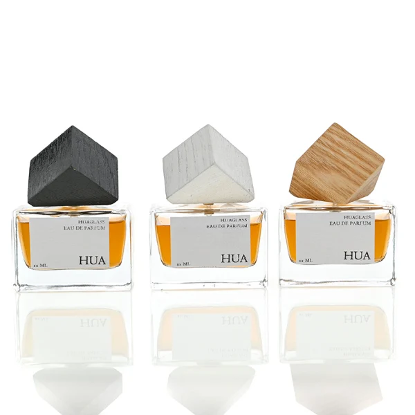 Modern cube-shaped caps featuring a glossy black finish.  Sleek rectangular perfume bottles crafted from heavy-base clear glass filled with golden-amber liquid.