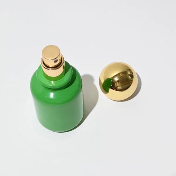 HUA0033 perfume bottle, apothecary-style round glass bottle with a solid opaque high-gloss color finish, featuring a spherical ball plastic cap with a smooth high-gloss shiny finish, elegant modern fragrance packaging design available in 30ml, 50ml, and 100ml