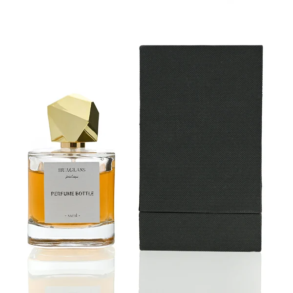 HUA0022 perfume bottle, heavy-base square cuboid glass bottle with clear finish, featuring a square paper label and an eye-catching irregular multi-faceted rock-shaped plastic cap with a high-gloss shiny finish and sharp geometric angles, elegant modern fragrance packaging design in 40ml