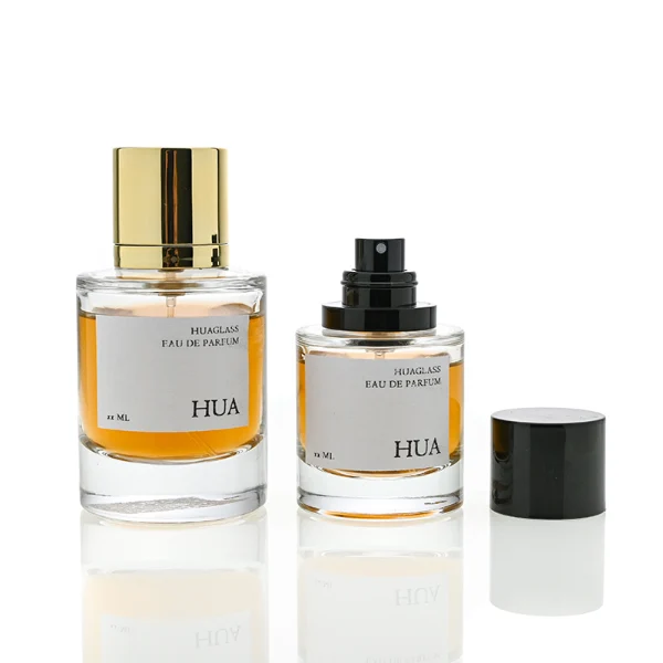 HUA0045 perfume bottle, heavy-base cylindrical round glass bottle with clear finish, featuring a square paper label, a coordinating collar neck accent, and a tall cylindrical aluminum cap with a smooth polished metallic finish, elegant modern fragrance packaging design available in 30ml, 50ml, and 100ml