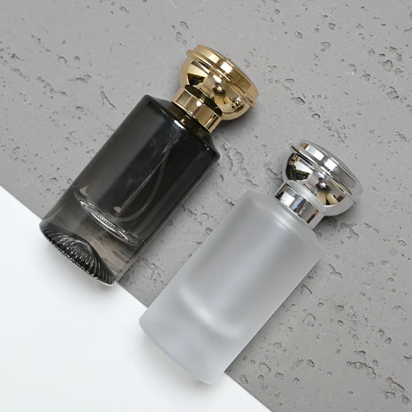 HUA0060 perfume bottle, heavy-base cylindrical round glass bottle with clear finish, featuring a matching neck and an ornate sculptural tiered crown plastic cap with a smooth high-gloss shiny finish, elegant modern fragrance packaging design available in 30ml, 50ml, and 100ml