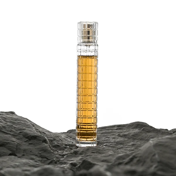 HUA0046 perfume bottle, tall slender cylindrical column glass bottle with clear finish and stacked grid-like textured ridges, featuring a gold collar neck accent and a matching tall transparent cylindrical plastic cap with a high-gloss shiny finish, modern geometric fragrance packaging design available in 30ml and 50ml