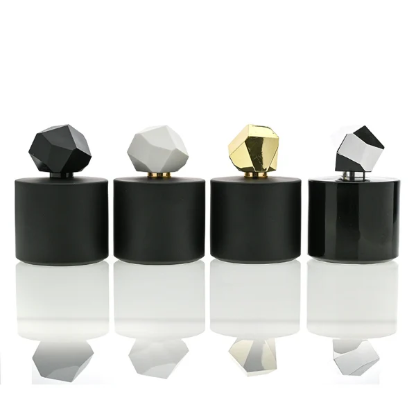 HUA0039 perfume bottle, heavy-base solid high-gloss opaque black cylindrical round glass bottle featuring a prominent asymmetrical multi-faceted polyhedral plastic cap with a smooth high-gloss shiny finish, modern dramatic fragrance packaging design available in 30ml, 50ml, and 100ml