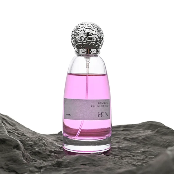 HUA0057 perfume bottle with clear oval glass body, gold or silver decorative textured spherical cap, 100 ml capacity, modern luxury fragrance packaging design.