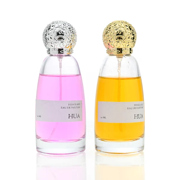 HUA0057 perfume bottle with clear oval glass body, gold or silver decorative textured spherical cap, 100 ml capacity, modern luxury fragrance packaging design.
