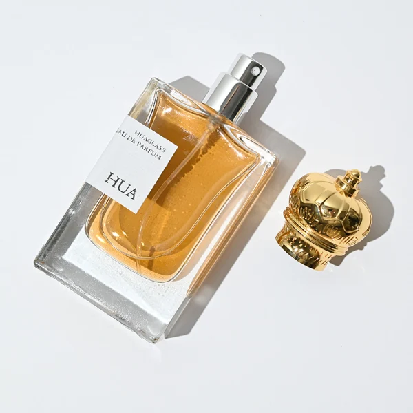 HUA0061 perfume bottle, heavy-base rectangular cuboid glass bottle with clear finish, featuring a square paper label, a matching neck, and an ornate imperial crown-shaped zinc alloy cap with a smooth polished gold finish, elegant modern fragrance packaging design available in 30ml and 50ml