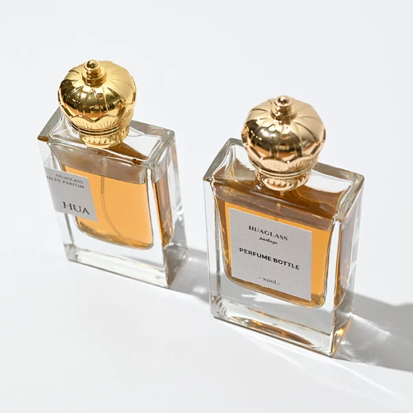 HUA0061 perfume bottle, heavy-base rectangular cuboid glass bottle with clear finish, featuring a square paper label, a matching neck, and an ornate imperial crown-shaped zinc alloy cap with a smooth polished gold finish, elegant modern fragrance packaging design available in 30ml and 50ml