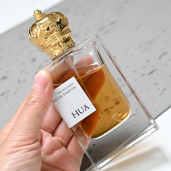 HUA0061 perfume bottle, heavy-base rectangular cuboid glass bottle with clear finish, featuring a square paper label, a matching neck, and an ornate imperial crown-shaped zinc alloy cap with a smooth polished gold finish, elegant modern fragrance packaging design available in 30ml and 50ml
