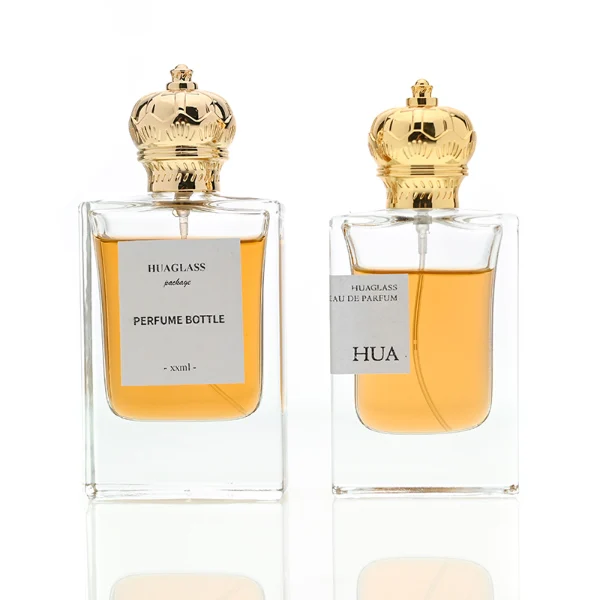 HUA0061 perfume bottle, heavy-base rectangular cuboid glass bottle with clear finish, featuring a square paper label, a matching neck, and an ornate imperial crown-shaped zinc alloy cap with a smooth polished gold finish, elegant modern fragrance packaging design available in 30ml and 50ml