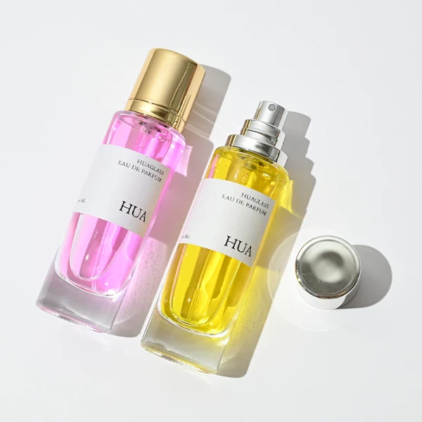 HUA0056 perfume bottle, heavy-base tall slender cylindrical round glass bottle with clear finish, featuring a wide wrapped paper label, a matching neck, and a tall cylindrical plastic cap with a smooth high-gloss shiny finish, elegant modern fragrance packaging design available in 30ml, 50ml, and 100ml