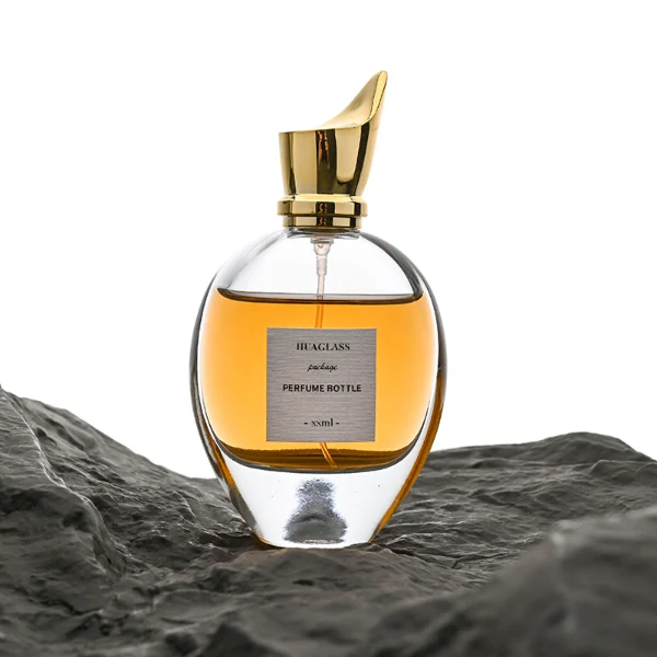 HUA0059 perfume bottle, heavy-base oval teardrop glass bottle with clear finish, featuring a square paper label, a matching neck, and a tall sculptural cylindrical plastic cap with a sharply angled sloping top in a smooth high-gloss shiny finish, elegant modern fragrance packaging design available in 30ml, 50ml, 75ml, and 100m
