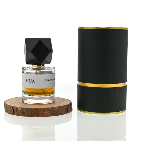 HUA0053 perfume bottle, heavy-base cylindrical round glass bottle with clear finish, featuring a wide wrapped paper label, a gold collar neck accent, and a unique polyhedral faceted diamond-shaped wood cap with subtle grain textures, elegant modern fragrance packaging design available in 30ml, 50ml, and 100ml