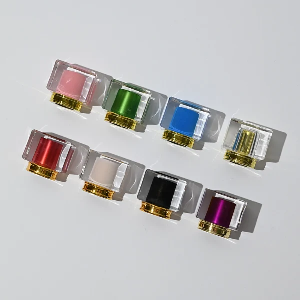 HUA0043 perfume bottle, heavy-base rectangular cuboid glass bottle with clear finish, featuring a side-aligned square paper label, a gold collar neck accent, and a unique double-layered square plastic cap with a transparent outer block and a colorful high-gloss shiny inner core, elegant modern fragrance packaging design available in 30ml, 50ml, and 100ml
