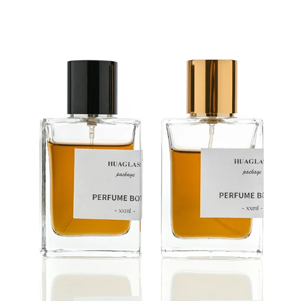 HUA0049 perfume bottle, heavy-base rectangular cuboid glass bottle with clear finish, featuring a corner-wrapped square paper label, a coordinating collar neck accent, and a tall cylindrical aluminum cap with a smooth polished metallic finish, elegant modern fragrance packaging design available in 30ml, 50ml, and 100ml