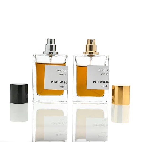 HUA0049 perfume bottle, heavy-base rectangular cuboid glass bottle with clear finish, featuring a corner-wrapped square paper label, a coordinating collar neck accent, and a tall cylindrical aluminum cap with a smooth polished metallic finish, elegant modern fragrance packaging design available in 30ml, 50ml, and 100ml
