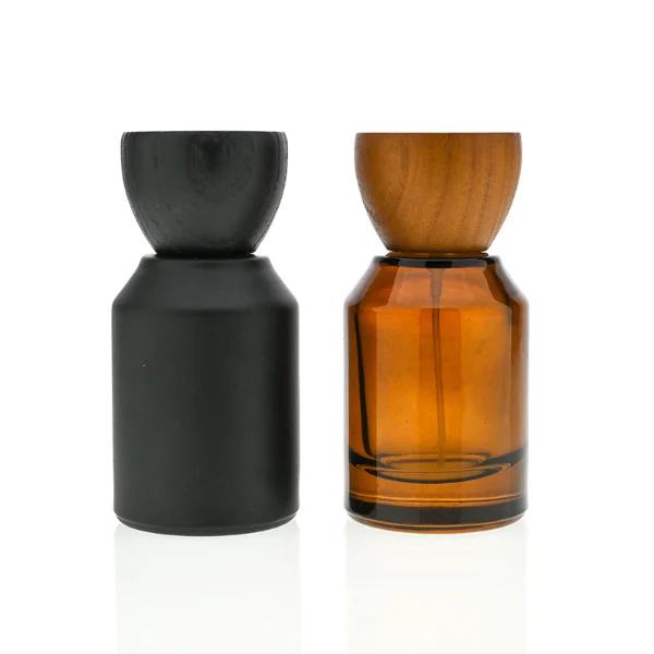 HUA0050 perfume bottle, cylindrical round glass bottle with multi-angled sloping beveled shoulders in solid high-gloss opaque black, clear amber, or frosted amber finish, featuring an eye-catching inverted conical cup-shaped wood cap with prominent natural wood grain lines, modern fragrance packaging design available in 30ml, 50ml, and 100ml
