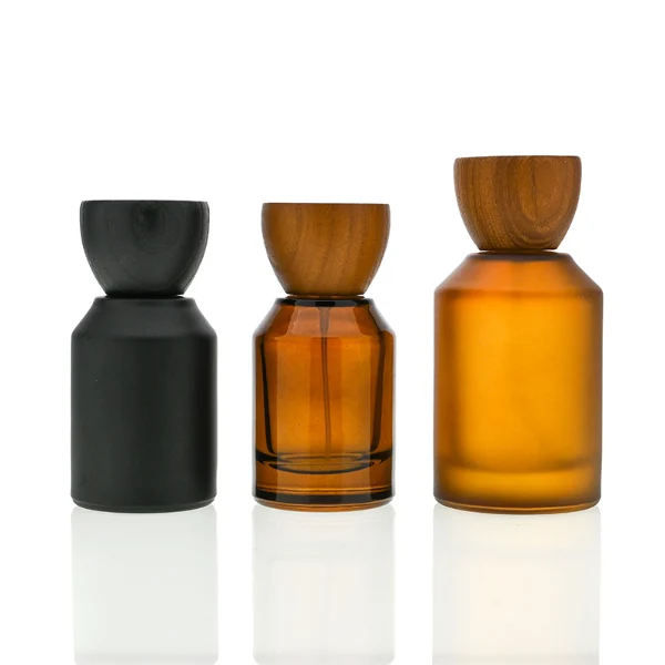 HUA0050 perfume bottle, cylindrical round glass bottle with multi-angled sloping beveled shoulders in solid high-gloss opaque black, clear amber, or frosted amber finish, featuring an eye-catching inverted conical cup-shaped wood cap with prominent natural wood grain lines, modern fragrance packaging design available in 30ml, 50ml, and 100ml
