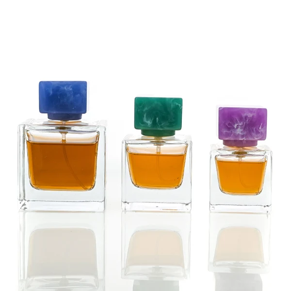 HUA0030 perfume bottle, heavy-base rectangular cuboid glass bottle with clear finish, featuring a matching neck, and a low-profile cylindrical resin cap with a colorful marbled finish, elegant modern fragrance packaging design available in 30ml, 50ml, and 100ml