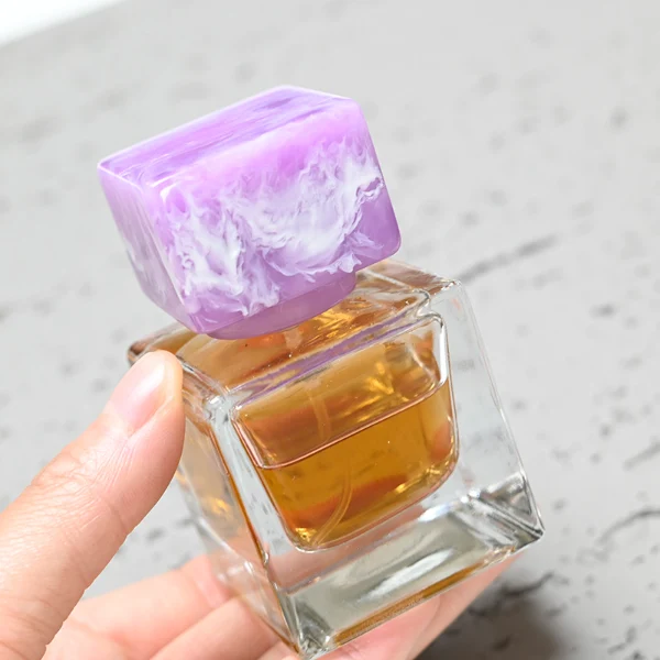 HUA0030 perfume bottle, heavy-base rectangular cuboid glass bottle with clear finish, featuring a matching neck, and a low-profile cylindrical resin cap with a colorful marbled finish, elegant modern fragrance packaging design available in 30ml, 50ml, and 100ml