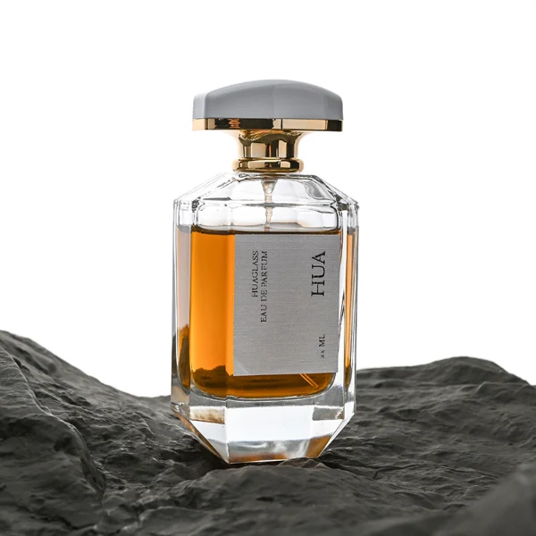HUA0013 perfume bottle, heavy-base octagonal faceted glass bottle with clear finish, featuring a square paper label, a matching neck, and an arched rectangular plastic cap with a smooth high-gloss shiny finish, elegant modern fragrance packaging design available in 30ml, 50ml, and 100ml