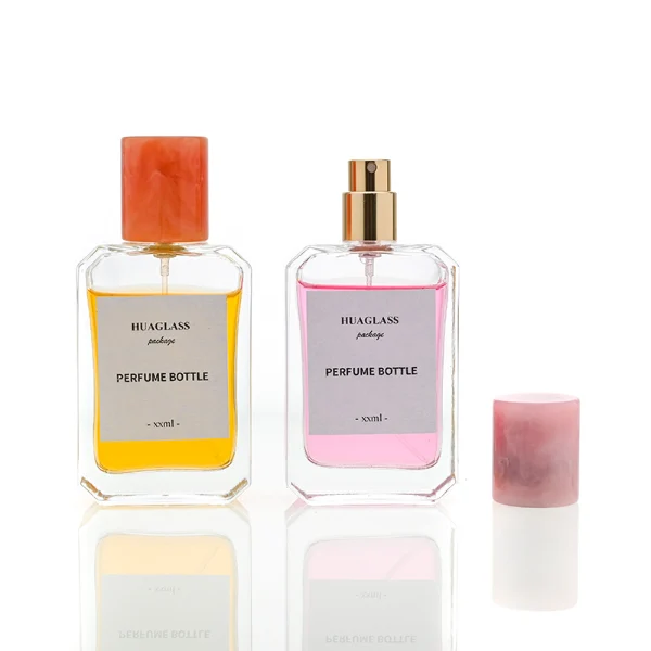 HUA0048 perfume bottle, heavy-base clear glass bottle with octagonal chamfered corners, featuring a square paper label and a tall cylindrical resin cap with an eye-catching marbled texture, elegant modern fragrance packaging design available in 30ml, 50ml, and 100ml
