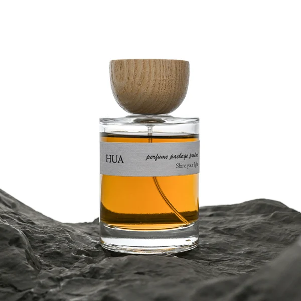 HUA0032 perfume bottle, heavy-base cylindrical round glass bottle with clear finish, featuring a horizontal paper label, a matching neck, and an inverted conical timber cap with a natural smooth grain finish, elegant modern fragrance packaging design available in 30ml, 50ml, and 100ml