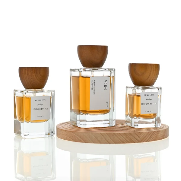 HUA0002 perfume bottle, heavy-base rectangular cuboid glass bottle with clear finish, featuring a square paper label, a matching neck, and an inverted conical timber cap with a natural grain finish, elegant modern fragrance packaging design available in 30ml, 50ml, and 100ml