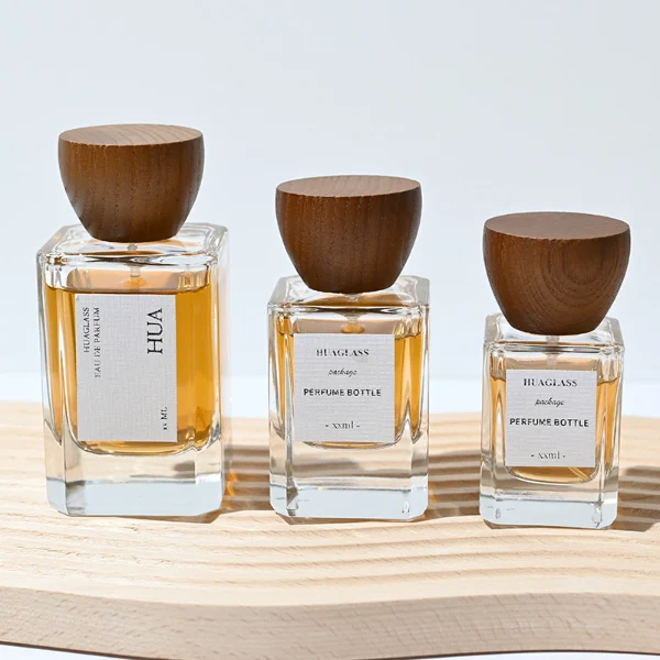 HUA0002 perfume bottle, heavy-base rectangular cuboid glass bottle with clear finish, featuring a square paper label, a matching neck, and an inverted conical timber cap with a natural grain finish, elegant modern fragrance packaging design available in 30ml, 50ml, and 100ml