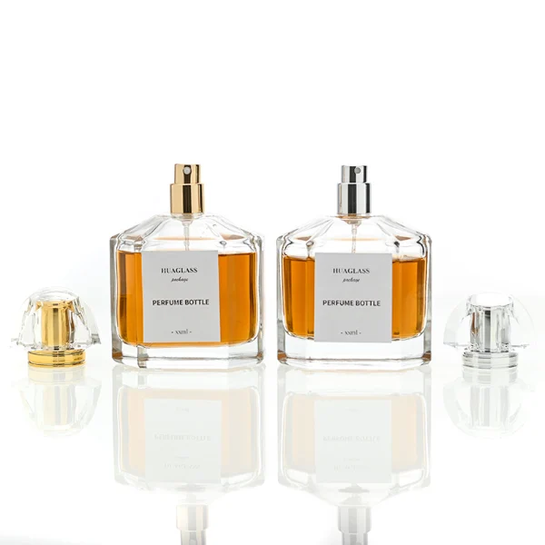 HUA0011 perfume bottle, luxury heavy-base polyhedral faceted glass bottle with high-transparency clear finish, featuring a square paper label and a brilliant multi-faceted crystalline acrylic plastic crown cap with a metallic inner core, elegant classic fragrance packaging design in 100ml