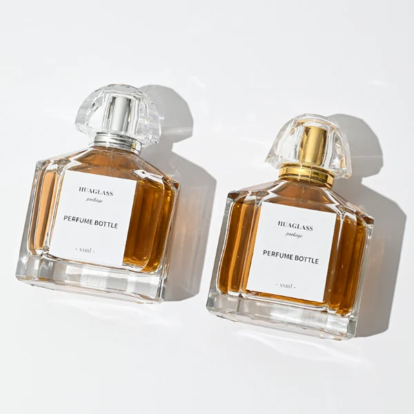 HUA0011 perfume bottle, luxury heavy-base polyhedral faceted glass bottle with high-transparency clear finish, featuring a square paper label and a brilliant multi-faceted crystalline acrylic plastic crown cap with a metallic inner core, elegant classic fragrance packaging design in 100ml