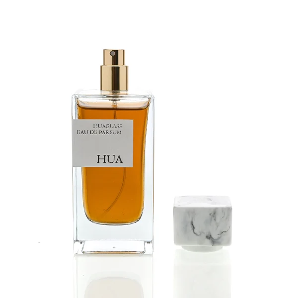 HUA0040 perfume bottle, heavy-base rectangular cuboid glass bottle with clear finish, featuring a side-aligned square paper label and a short rectangular block-shaped resin cap with an eye-catching marbled texture, elegant modern fragrance packaging design available in 15ml, 30ml, 50ml, and 100ml