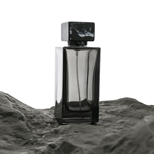 HUA0040 perfume bottle, heavy-base rectangular cuboid glass bottle with clear finish, featuring a side-aligned square paper label and a short rectangular block-shaped resin cap with an eye-catching marbled texture, elegant modern fragrance packaging design available in 15ml, 30ml, 50ml, and 100ml