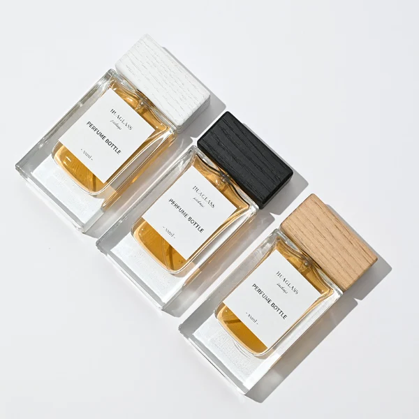 HUA0020 perfume bottle, heavy-base rectangular cuboid glass bottle with clear finish, featuring a square paper label, a matching neck, and a block-shaped rectangular timber cap with a natural smooth grain finish, elegant modern fragrance packaging design available in 30ml, 50ml, and 100ml