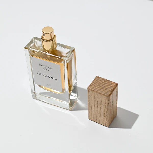 HUA0020 perfume bottle, heavy-base rectangular cuboid glass bottle with clear finish, featuring a square paper label, a matching neck, and a block-shaped rectangular timber cap with a natural smooth grain finish, elegant modern fragrance packaging design available in 30ml, 50ml, and 100ml