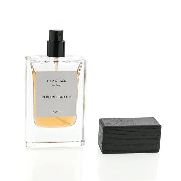 HUA0020 perfume bottle, heavy-base rectangular cuboid glass bottle with clear finish, featuring a square paper label, a matching neck, and a block-shaped rectangular timber cap with a natural smooth grain finish, elegant modern fragrance packaging design available in 30ml, 50ml, and 100ml