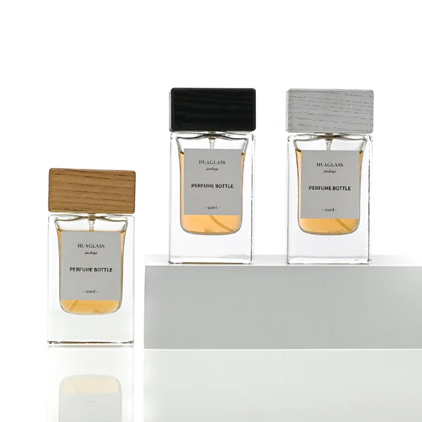 HUA0020 perfume bottle, heavy-base rectangular cuboid glass bottle with clear finish, featuring a square paper label, a matching neck, and a block-shaped rectangular timber cap with a natural smooth grain finish, elegant modern fragrance packaging design available in 30ml, 50ml, and 100ml