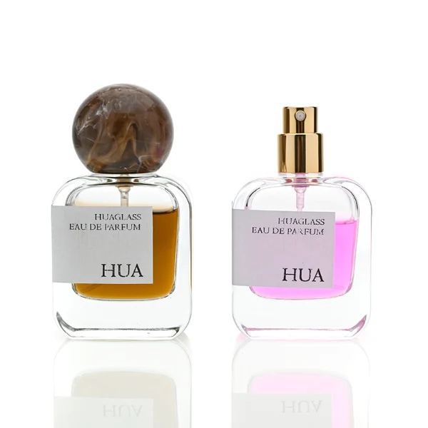 HUA0042 perfume bottle, clear flattened oval flask glass bottle featuring a prominent spherical ball-shaped resin cap with an eye-catching marbled texture and organic fluid swirls, modern playful fragrance packaging design available in 30ml, 50ml, and 100ml