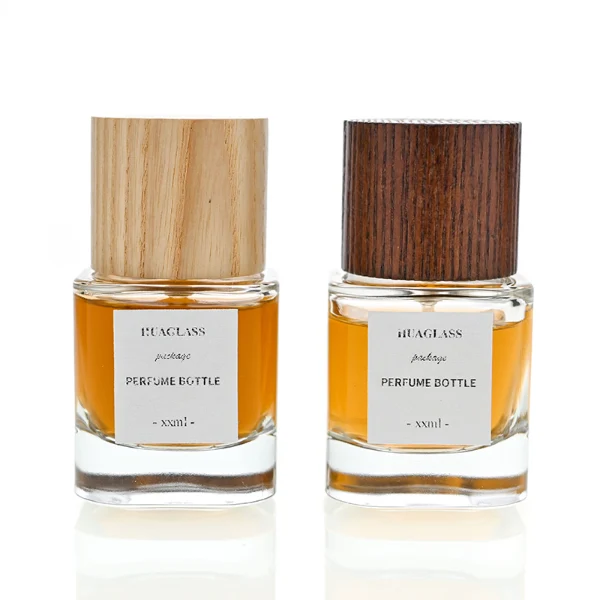 HUA0008 perfume bottle, luxury heavy-base cylindrical glass bottle with high-transparency clear finish, featuring a square paper label and a prominent tall flush-fit cylindrical natural textured wooden cap showcasing deep vertical wood grains, minimalist elegant fragrance packaging design available in 30ml, 50ml, and 100ml