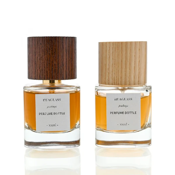 HUA0008 perfume bottle, luxury heavy-base cylindrical glass bottle with high-transparency clear finish, featuring a square paper label and a prominent tall flush-fit cylindrical natural textured wooden cap showcasing deep vertical wood grains, minimalist elegant fragrance packaging design available in 30ml, 50ml, and 100ml