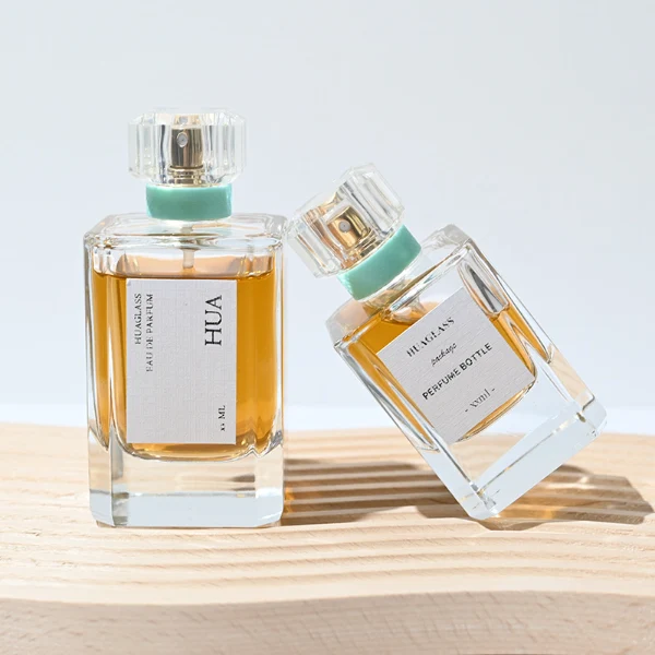 Vintage-inspired clear square plastic caps with a light mint green neck accent ring. Elegant square perfume bottles crafted from heavy-base clear glass filled with golden-amber liquid.