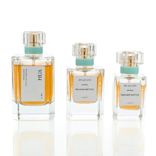  Vintage-inspired clear square plastic caps with a light mint green neck accent ring. Elegant square perfume bottles crafted from heavy-base clear glass filled with golden-amber liquid.