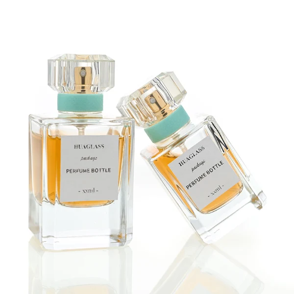 Vintage-inspired clear square plastic caps with a light mint green neck accent ring. Elegant square perfume bottles crafted from heavy-base clear glass filled with golden-amber liquid.