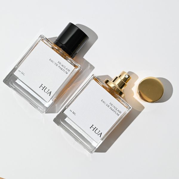 HUA0065 perfume bottles, rectangular clear glass with gold and black metallic caps, amber liquid, modern elegant design, 35ml 50ml 100ml.
