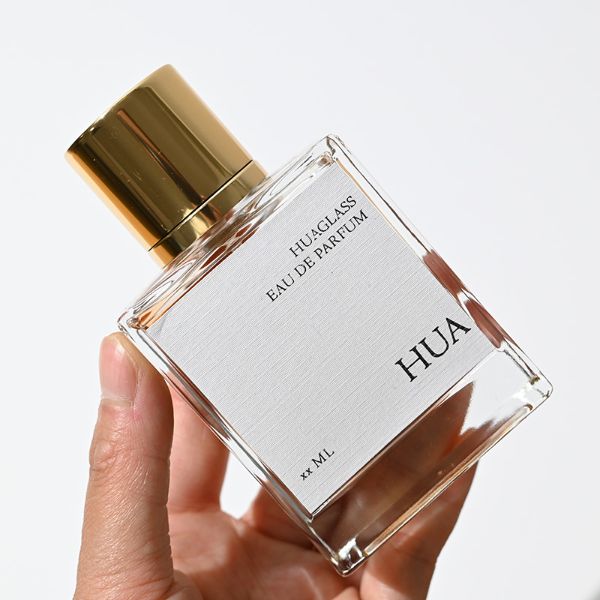 HUA0065 perfume bottles, rectangular clear glass with gold and black metallic caps, amber liquid, modern elegant design, 35ml 50ml 100ml.