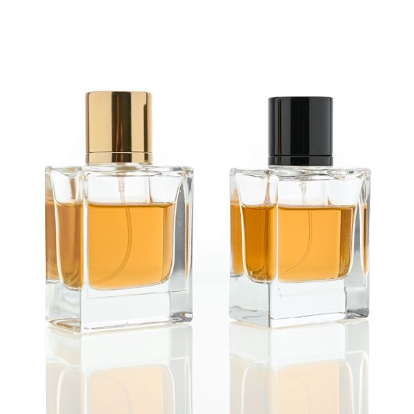 HUA0065 perfume bottles, rectangular clear glass with gold and black metallic caps, amber liquid, modern elegant design, 35ml 50ml 100ml.