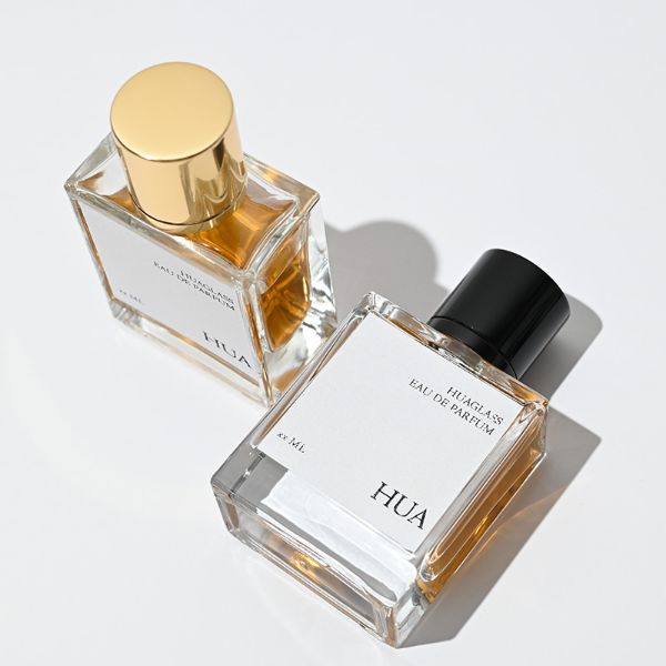 HUA0065 perfume bottles, rectangular clear glass with gold and black metallic caps, amber liquid, modern elegant design, 35ml 50ml 100ml.